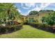Lush front yard with manicured hedges and palms leading up to a bright yellow single-Gathering home at 10321 Shady Oak Ln, Seminole, FL 33777