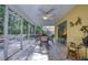 Relaxing screened-in patio includes ceiling fan and an outdoor dining set at 10321 Shady Oak Ln, Seminole, FL 33777