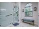 The elegant walk-in shower features a glass enclosure and marbled floors at 10321 Shady Oak Ln, Seminole, FL 33777