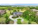 Stunning aerial view of a sprawling estate with a circular driveway, lush landscaping, and a serene lake at 10614 Low Oak Terrace, Thonotosassa, FL 33592