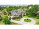 Stunning aerial view of a sprawling estate with a circular driveway, lush landscaping, and a serene lake at 10614 Low Oak Terrace, Thonotosassa, FL 33592
