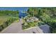 An aerial view shows a waterfront house with a dock, trees, and parking at 10614 Low Oak Terrace, Thonotosassa, FL 33592