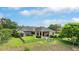 Expansive backyard featuring lush landscaping, a covered patio, and a cozy fire pit for outdoor enjoyment at 10614 Low Oak Terrace, Thonotosassa, FL 33592