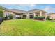 Expansive backyard featuring lush landscaping, a covered patio, and a cozy fire pit for outdoor enjoyment at 10614 Low Oak Terrace, Thonotosassa, FL 33592