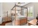 Cozy bedroom featuring a four-poster bed, wood floors, a ceiling fan, and shuttered windows at 10614 Low Oak Terrace, Thonotosassa, FL 33592
