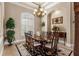 Formal dining room features an elegant chandelier, large window, and beautiful wood furniture at 10614 Low Oak Terrace, Thonotosassa, FL 33592