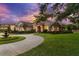 A beautifully landscaped home features a circular driveway, fountain, and stone accents at 10614 Low Oak Terrace, Thonotosassa, FL 33592
