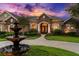 Close-up view of the home's front entrance and arched doorway with meticulously maintained landscaping at 10614 Low Oak Terrace, Thonotosassa, FL 33592