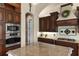 This kitchen features custom cabinets, granite countertops, stainless steel appliances, and an island with seating at 10614 Low Oak Terrace, Thonotosassa, FL 33592