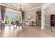 Well-lit living room with French doors, tile flooring, and a decorative chandelier at 10614 Low Oak Terrace, Thonotosassa, FL 33592