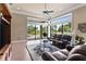 Living room featuring leather couches, a glass table, and views of the backyard greenery at 10614 Low Oak Terrace, Thonotosassa, FL 33592