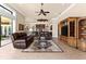 Spacious living room features leather furniture, a ceiling fan, and access to the backyard at 10614 Low Oak Terrace, Thonotosassa, FL 33592