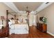 Spacious primary bedroom features a canopy bed, wood floors, a ceiling fan, and plenty of natural light at 10614 Low Oak Terrace, Thonotosassa, FL 33592