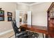 Office with large desk, executive chair, built-in shelves and view of entryway, arched ceiling, and dining area at 10614 Low Oak Terrace, Thonotosassa, FL 33592
