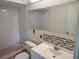Bathroom features an extra long mirror above the sink with a tiled backsplash and pink tub at 1155 Royalwood Dr, Holiday, FL 34690