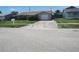Charming home with pink stone accents, attached garage, and driveway, nestled in a residential street at 1155 Royalwood Dr, Holiday, FL 34690