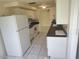 This kitchen offers white appliances, tile flooring, and neutral paint, waiting for your modern updates at 1155 Royalwood Dr, Holiday, FL 34690