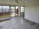 An enclosed patio boasts neutral flooring, walls, and ceiling fan providing a versatile, covered outdoor space at 1155 Royalwood Dr, Holiday, FL 34690
