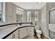 Bright bathroom features decorative wallpaper, white cabinets, updated fixtures, and framed mirror over the sink at 119 E Saint Johns Way, Apollo Beach, FL 33572