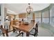 Open dining room features a wooden table, six chairs, an elegant chandelier, and views into the kitchen at 119 E Saint Johns Way, Apollo Beach, FL 33572