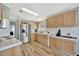 Well-lit kitchen boasts stainless steel appliances, wood-look vinyl flooring, light cabinets, and white backsplash at 119 E Saint Johns Way, Apollo Beach, FL 33572