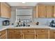Classic kitchen with wooden cabinets, white countertops, a double sink, and a window for natural light at 119 E Saint Johns Way, Apollo Beach, FL 33572