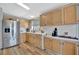 Bright kitchen features light wooden cabinetry, stainless steel appliances, plenty of counter space, and wood look floors at 119 E Saint Johns Way, Apollo Beach, FL 33572