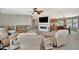 A spacious living room area features a large sectional sofa, fireplace, and view of dining area at 119 E Saint Johns Way, Apollo Beach, FL 33572