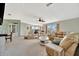 Bright living room featuring neutral walls, carpet, ceiling fan, and comfortable beige sofas and armchairs at 119 E Saint Johns Way, Apollo Beach, FL 33572