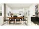 Modern dining room featuring a table with seating for six, stylish decor, and an open-concept design leading to the kitchen at 12716 Lily Quartz Loop, Parrish, FL 34219