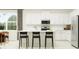 Modern kitchen with white cabinets, stainless steel appliances, an island with seating, and ample counter space at 12716 Lily Quartz Loop, Parrish, FL 34219