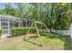 Backyard view with a swing set and screened pool at 12712 Stanwyck Cir, Tampa, FL 33626