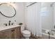 Charming bathroom featuring a stylish wood vanity, modern black faucet, and shower-tub combination at 12712 Stanwyck Cir, Tampa, FL 33626