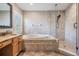 Well-lit bathroom with granite counters, soaker tub and tiled walk-in shower at 12712 Stanwyck Cir, Tampa, FL 33626
