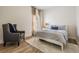 Well-lit bedroom with neutral paint and light-colored carpet has an accent chair and view of the outside at 12712 Stanwyck Cir, Tampa, FL 33626