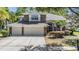 Charming two-story home features stone accents and a spacious three-car garage, nestled in a lush, green neighborhood at 12712 Stanwyck Cir, Tampa, FL 33626