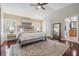 Inviting main bedroom with hardwood floors, a ceiling fan, and a view into the bathroom at 12712 Stanwyck Cir, Tampa, FL 33626