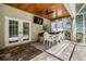 Covered outdoor living space with brick floor, a dining table, and a clear view of the pool through French doors at 12712 Stanwyck Cir, Tampa, FL 33626