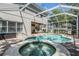 Backyard with pool and hot tub, covered patio, grill, and seating in a screened-in enclosure at 12712 Stanwyck Cir, Tampa, FL 33626