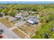 Aerial view showcasing the property with a fenced yard, two buildings, tropical landscaping, and parking at 1322 Idlewild Dr, Clearwater, FL 33755