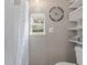 Neutral bathroom with a shower, decorative artwork, and built-in storage shelves with soft towels at 1322 Idlewild Dr, Clearwater, FL 33755