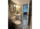 Well-lit bathroom featuring a modern sink, patterned floors, and a tiled shower with shelves at 1322 Idlewild Dr, Clearwater, FL 33755