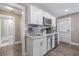 Bright, updated kitchen with white cabinetry, stainless steel appliances, and convenient access to the bathroom at 1322 Idlewild Dr, Clearwater, FL 33755