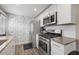 Modern kitchen featuring stainless steel appliances, white cabinets, and granite countertops at 1322 Idlewild Dr, Clearwater, FL 33755