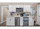 Efficient kitchen setup with white cabinets, stainless steel appliances, and ample counter space at 1322 Idlewild Dr, Clearwater, FL 33755