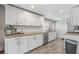 Bright kitchen featuring white cabinets, stainless steel appliances, and granite countertops at 1322 Idlewild Dr, Clearwater, FL 33755