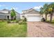 Beautiful two-story home with a well-kept lawn and a brick-paved driveway at 13876 Stansil Ave, Odessa, FL 33556