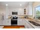 Well-lit kitchen featuring granite countertops, stainless steel appliances, and white cabinetry at 1666 S Lake Ave # 1, Clearwater, FL 33756