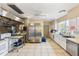 A commercial style kitchen with stainless steel appliances, white cabinets, and tile flooring at 1666 S Lake Ave # 1, Clearwater, FL 33756