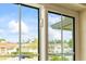 The window view showcases neighborhood homes, a lush tree, and bright skies at 1666 S Lake Ave # 1, Clearwater, FL 33756